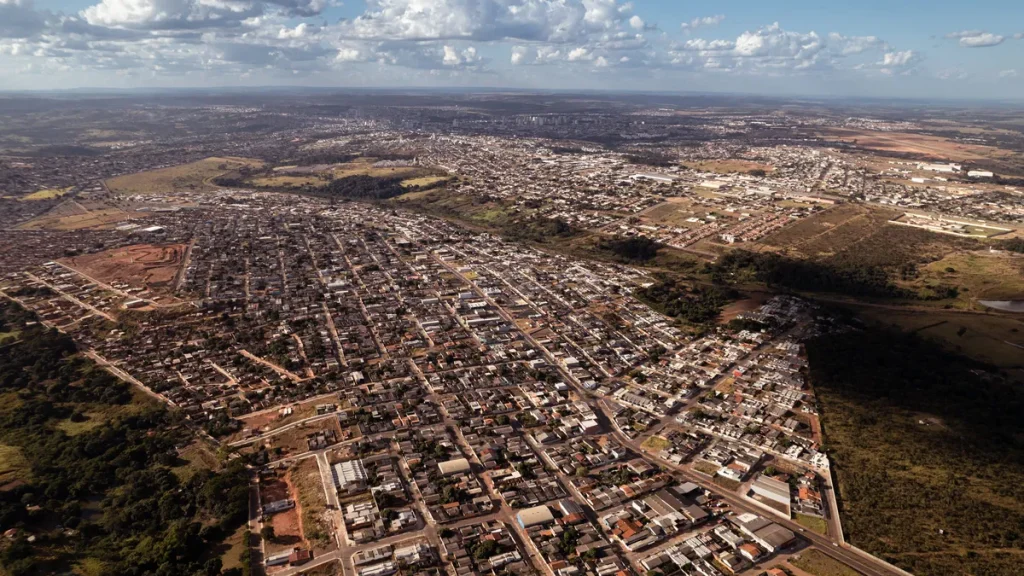 Vista aérea de Anápolis, Goiás, com prédios modernos em desenvolvimento e paisagem urbana.