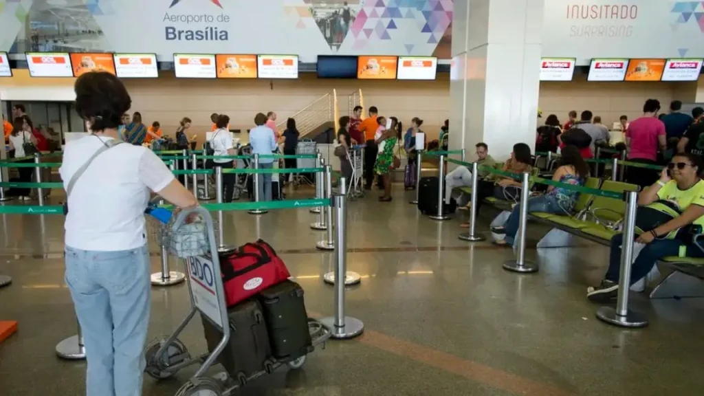 Vista aérea de um shopping center a céu aberto adjacente a um aeroporto movimentado em Brasília.