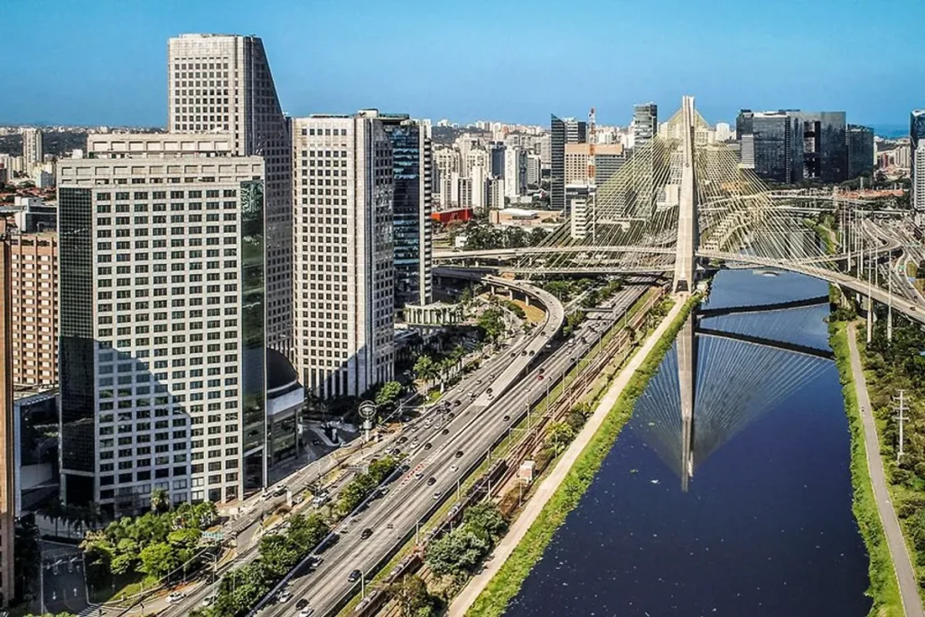 Rua arborizada e plana no Brooklin, São Paulo, com arquitetura de luxo e pessoas caminhando.