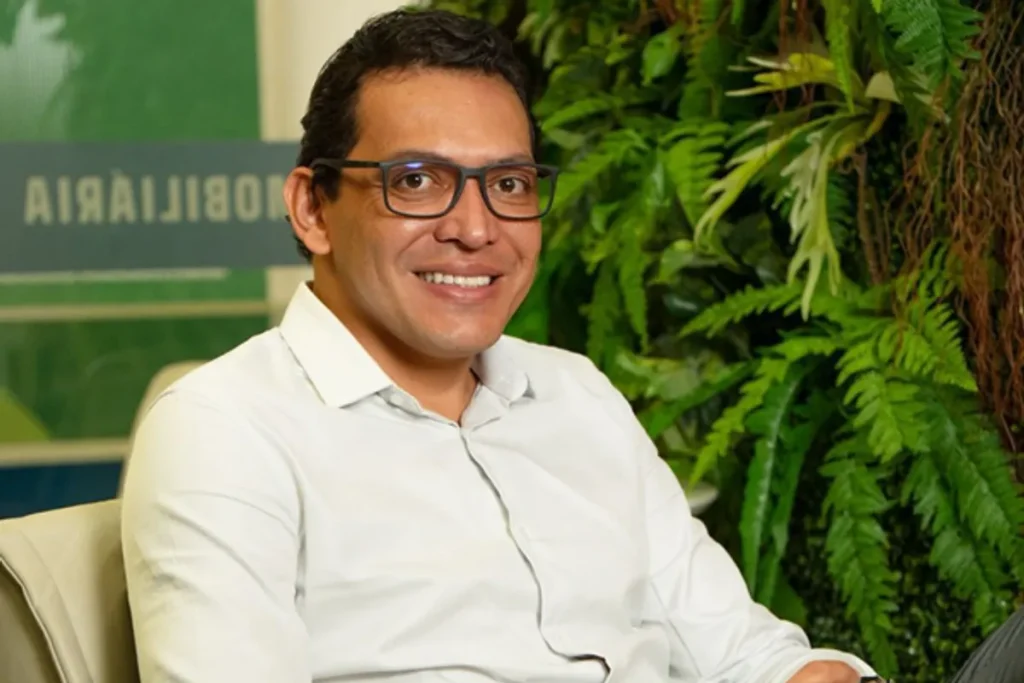 Corretor apresenta plano de investimento imobiliário com cartas contempladas em escritório moderno.