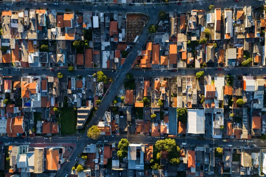 Família da classe média olhando placa de aluga-se em frente a um prédio de apartamentos no Brasil.