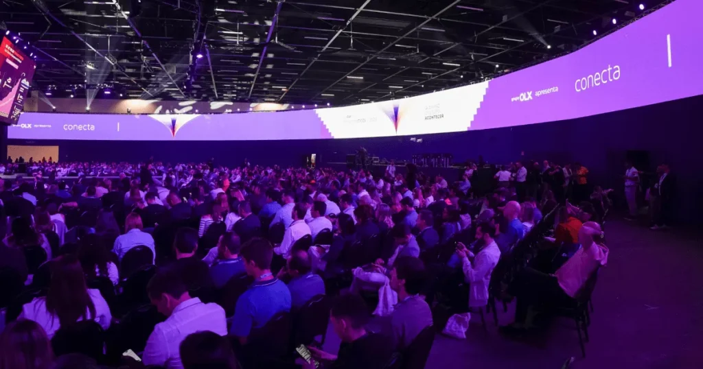 Profissionais em evento de mercado imobiliário discutindo tendências e inovação.