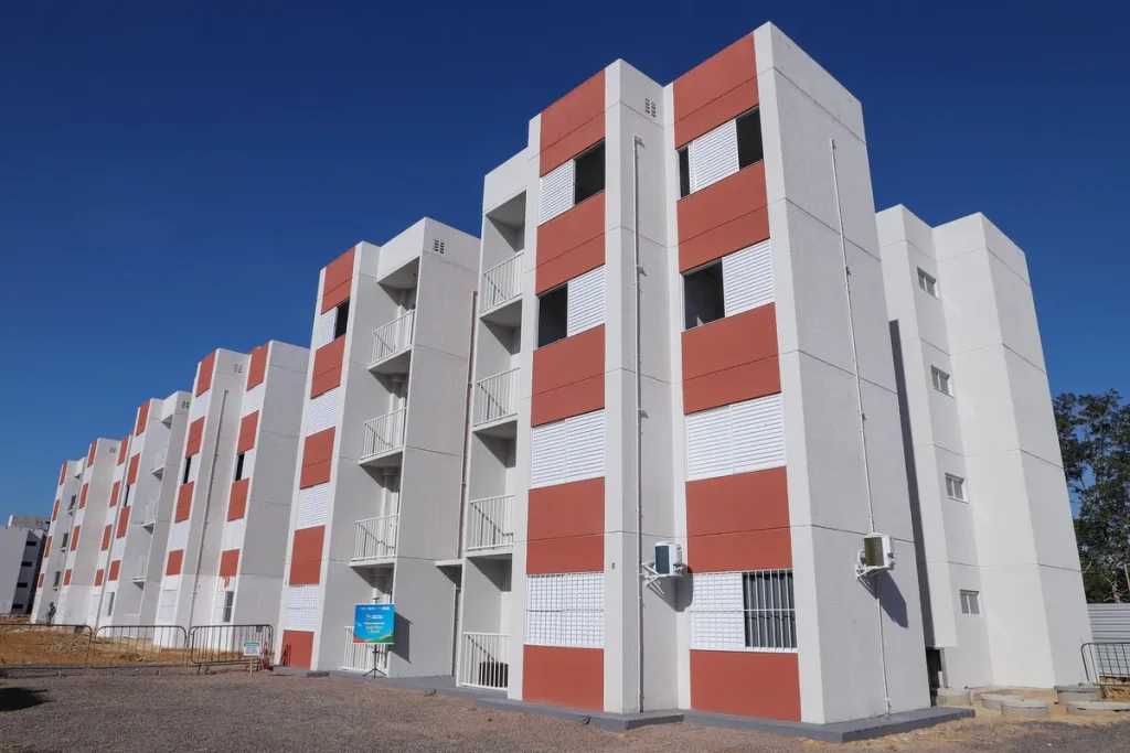Família sorri em frente a sua nova casa financiada pelo Minha Casa, Minha Vida com novas regras.
