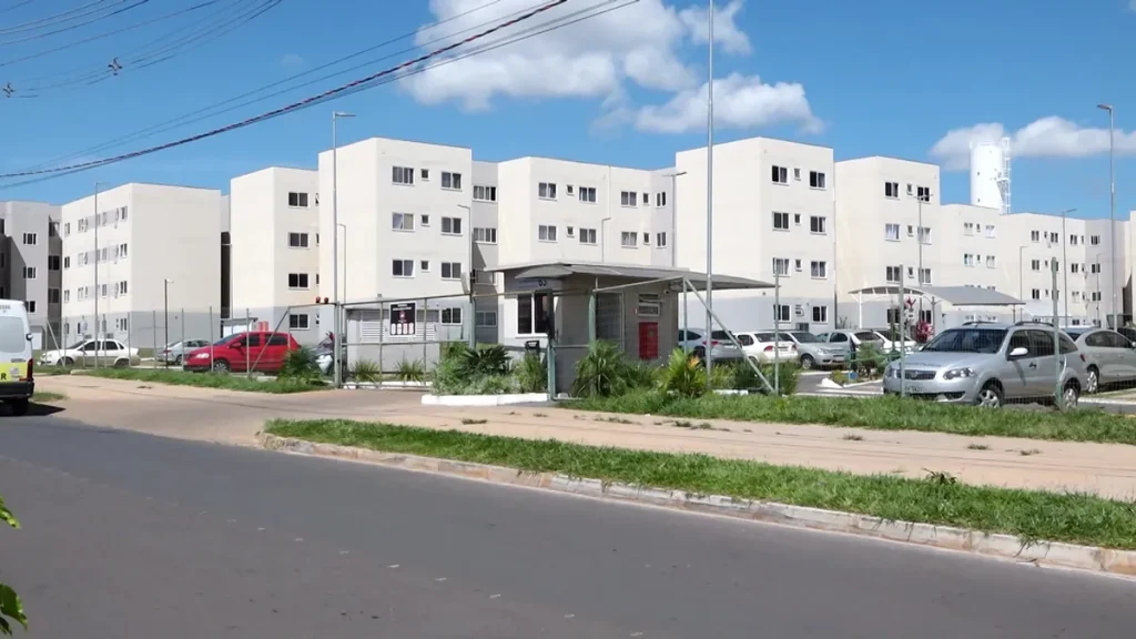 Família feliz em frente à sua nova casa financiada pelo programa Minha Casa, Minha Vida.