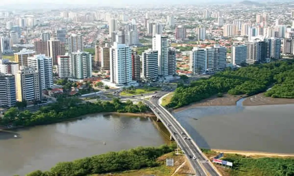 Horizonte urbano de Aracaju com novos empreendimentos imobiliários ao pôr do sol.