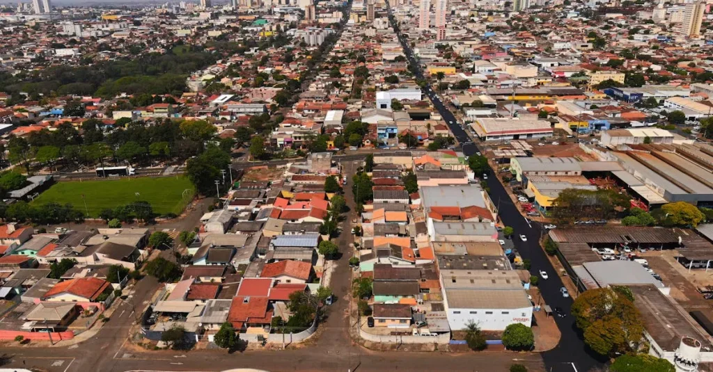 Visão aérea do bairro planejado Colinas de Camboriú em contraste com a paisagem urbana de Balneário Camboriú ao fundo.