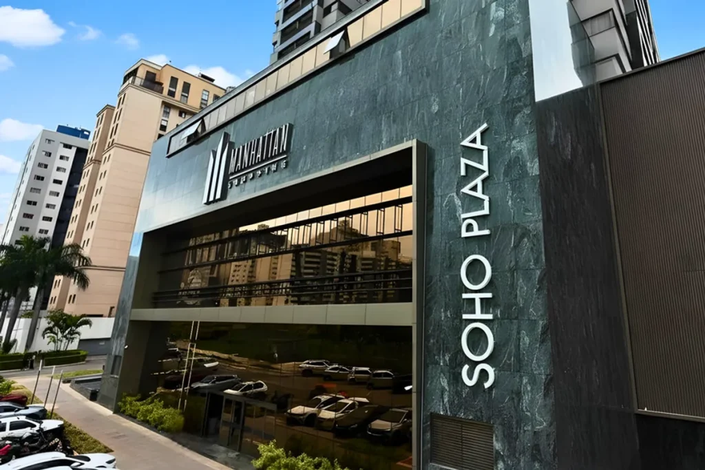 Fachada do Manhattan Shopping em Brasília, destacando sua arquitetura moderna e iluminação noturna, representando a excelência em engenharia.