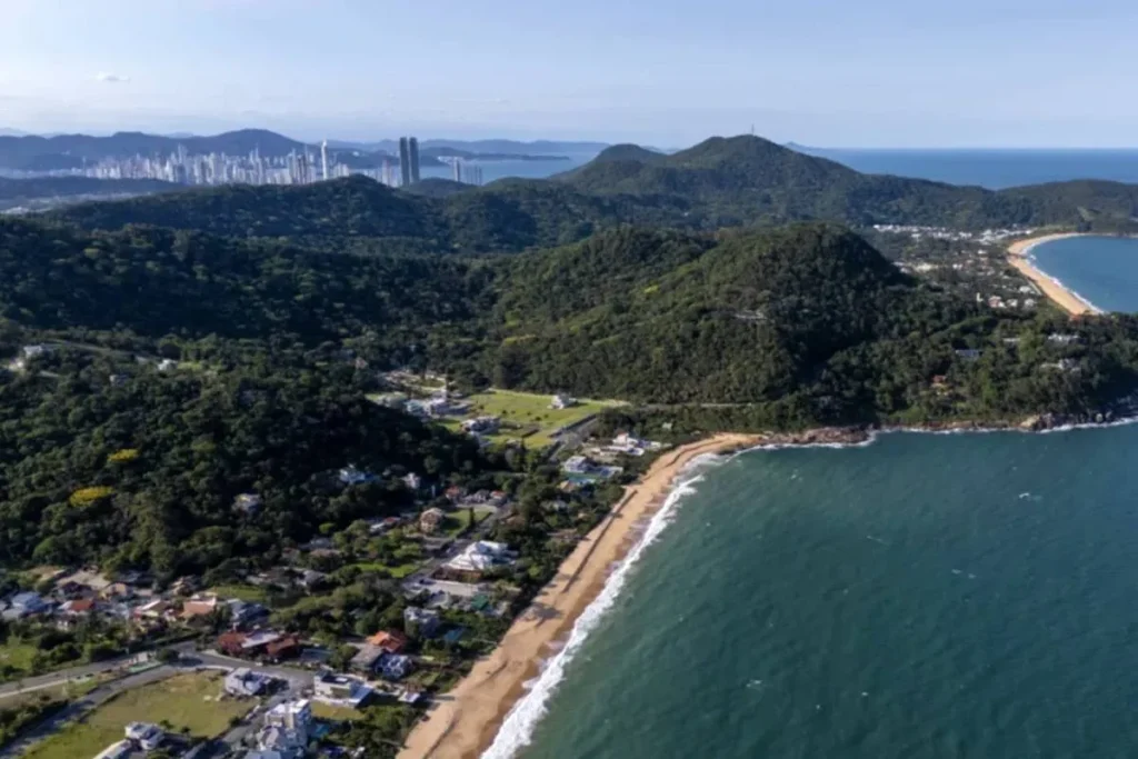 Praia secreta e preservada em Balneário Camboriú com mansões de luxo ao fundo