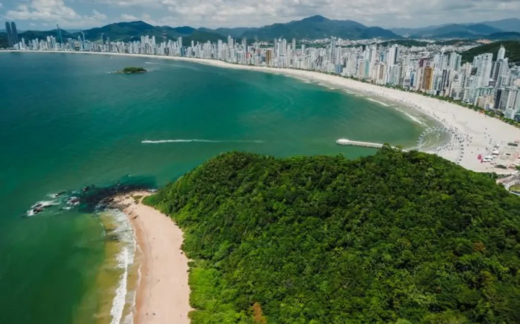 Vista aérea de Balneário Camboriú com arranha-céus modernos e praia ao pôr do sol