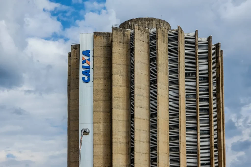 Agência da Caixa Econômica Federal com clientes acessando serviços de crédito imobiliário.