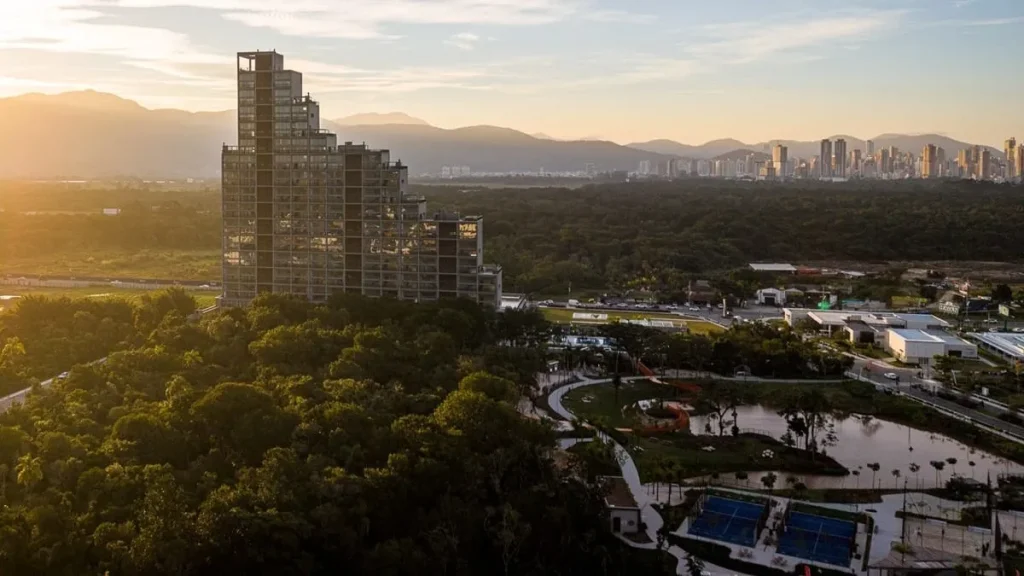 Vista aérea do prédio residencial Vista Jardins, o primeiro no bairro-parque Vivapark em Porto Belo, SC, com varandas e piscinas privativas.