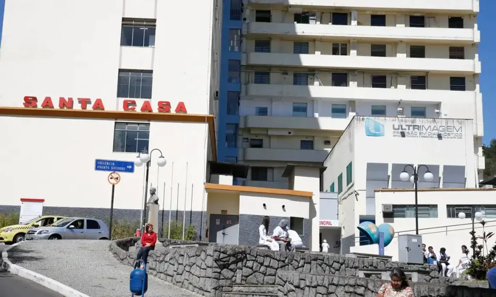 Fachada de Santa Casa com equipe médica sorrindo, simbolizando esperança e confiança no sistema de saúde.