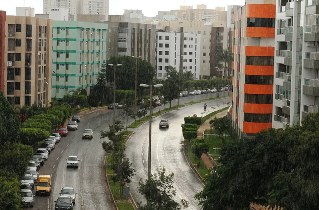 Família em frente a imóvel em construção em Brasília, simbolizando o sonho da casa própria e as dificuldades de financiamento.