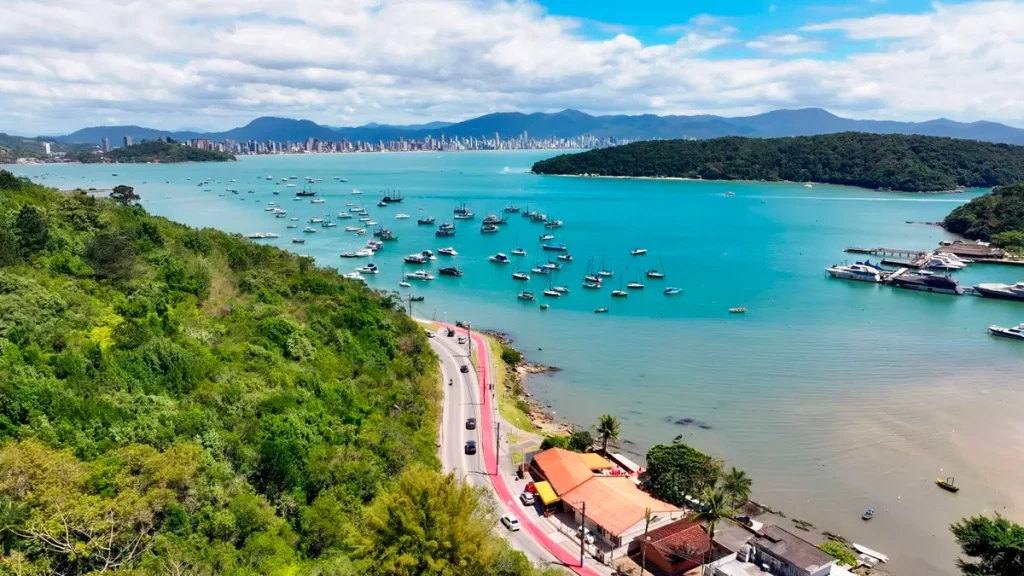 Pôr do sol na orla de Balneário Camboriú, destacando a combinação de urbanismo moderno e beleza natural como um destino desejado.