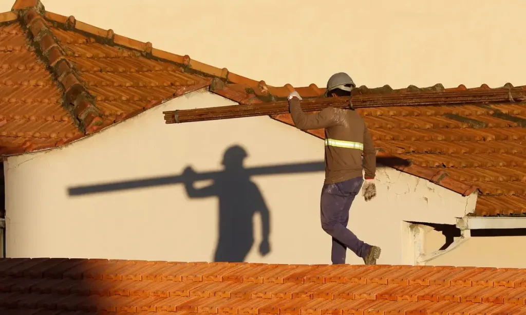 Canteiro de obras moderno no Distrito Federal com gruas e edifícios em construção ao pôr do sol.