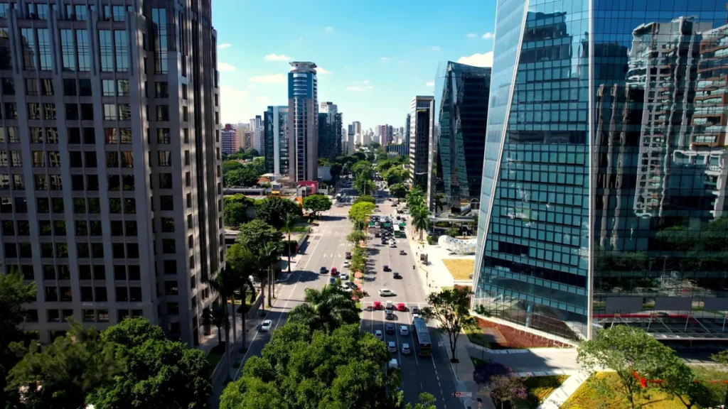 Edifício de escritórios corporativos e galpões logísticos em área urbana movimentada.