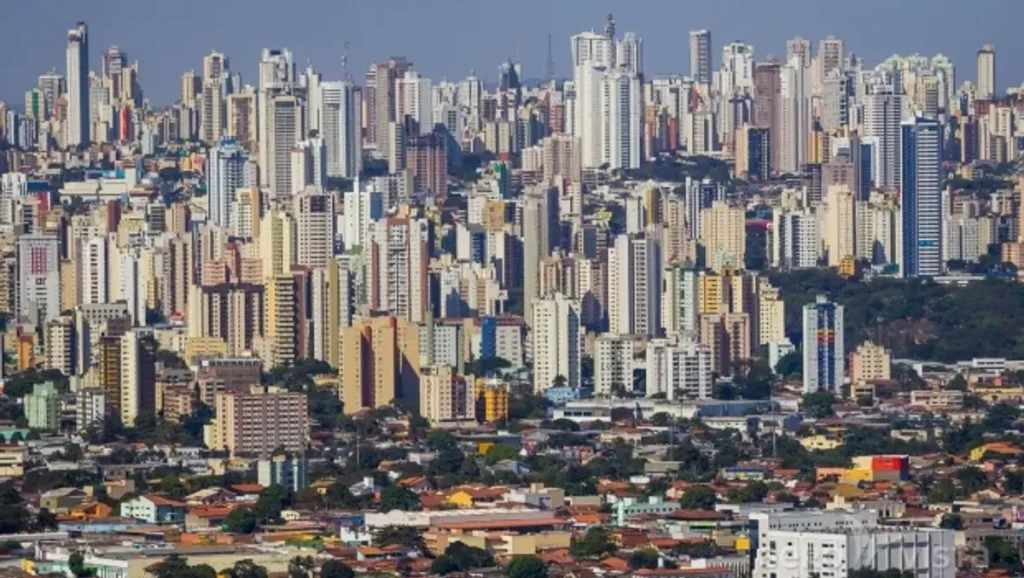 Vista aérea noturna de um bairro de luxo em Goiânia, com edifícios modernos e iluminação vibrante.