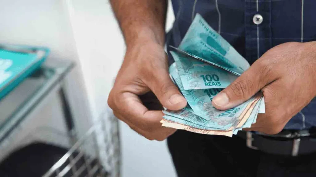 Trabalhador brasileiro comemora recebimento de lucro do FGTS em seu celular