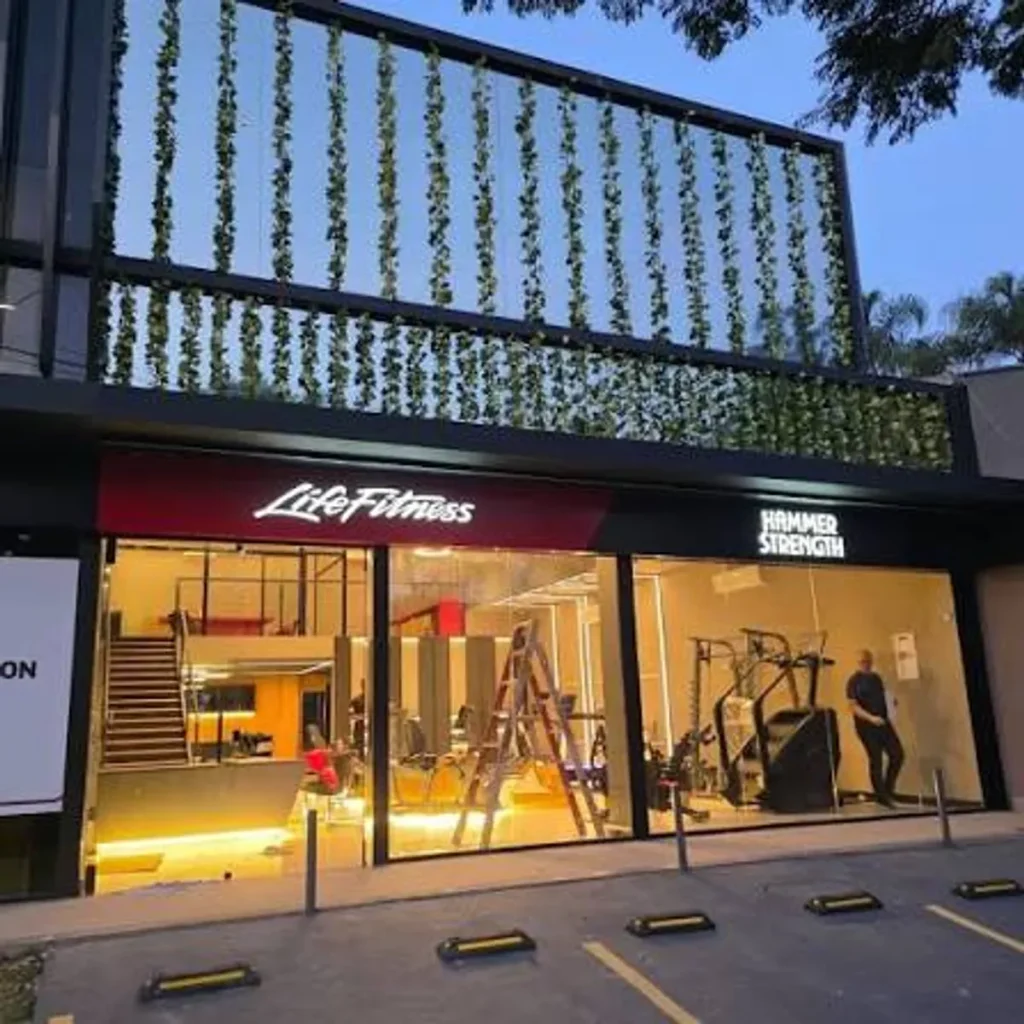 Cliente experimentando equipamento de ginástica de alta tecnologia em uma nova loja da Life Fitness no Brasil.