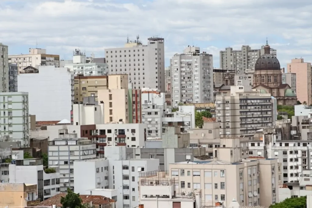 Empreendimento imobiliário de alto padrão em Porto Alegre com vista para a cidade ao pôr do sol.