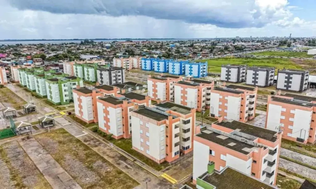 Família feliz em frente a uma casa nova, simbolizando a conquista da moradia com o uso do FGTS.