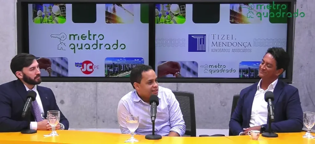 Casal feliz celebra a regularização de seu imóvel com chaves e documentos em mãos, em frente à sua casa.