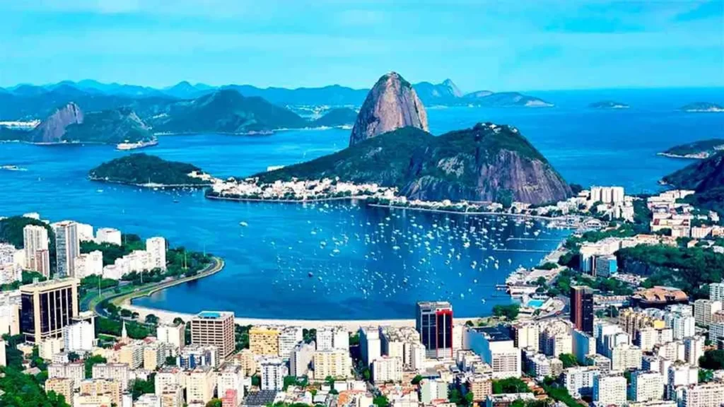 Edifício de apartamentos moderno com vista para o mar no Rio de Janeiro, atraindo turistas e investidores.